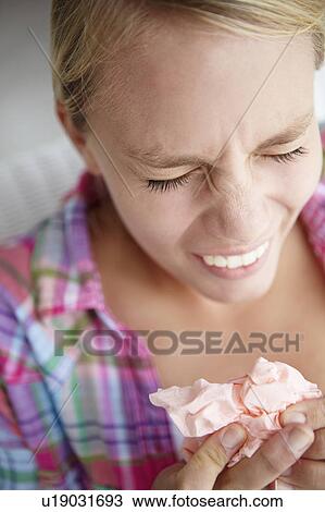Stock Image - Teenage girl sneezing. Fotosearch
