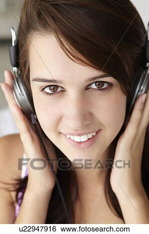 Stock Photograph - Teenage girl wearing headphones. Fotosearch