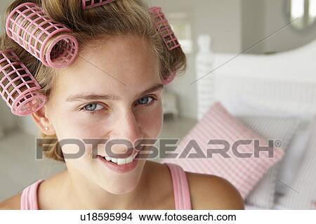 Picture - Teenage girl with hair in curlers. Fotosearch