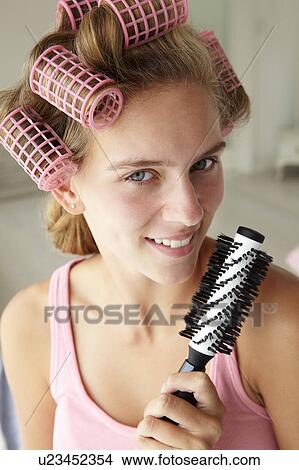 Picture - Teenage girl with hair in curlers. Fotosearch