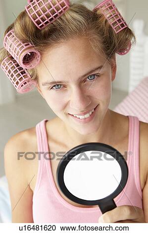 Stock Image - Teenage girl with hair in curlers. Fotosearch