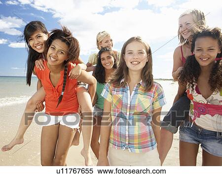 Stock Photography - Teenage girls walking on beach. Fotosearch
