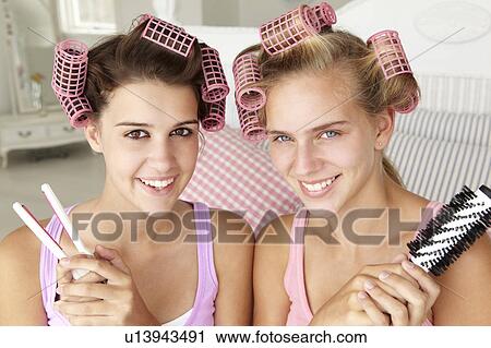 Stock Image - Teenage girls with hair in curlers. Fotosearch