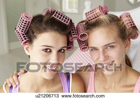 Stock Image - Teenage girls with hair in curlers. Fotosearch