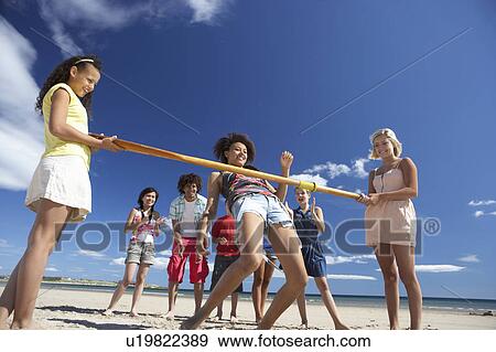 Teenagers doing limbo dance on beach View Large Photo Image Stock Photo - Teenagers doing limbo dance on beach. Fotosearch