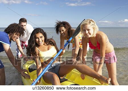Teenagers in sea with canoe View Large Photo Image Stock Image - Teenagers in sea with canoe. Fotosearch