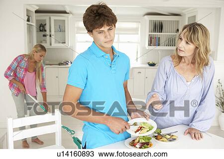 Stock Image - Teenagers reluctant to do housework. Fotosearch