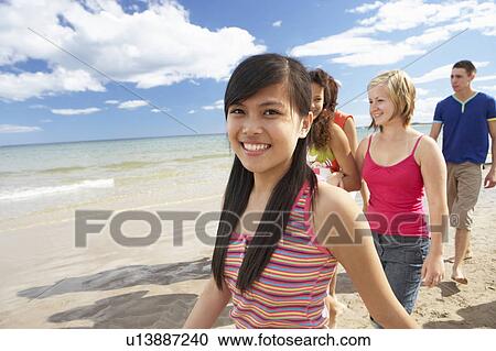 Teenagers walking on beach View Large Photo Image Stock Image - Teenagers walking on beach. Fotosearch