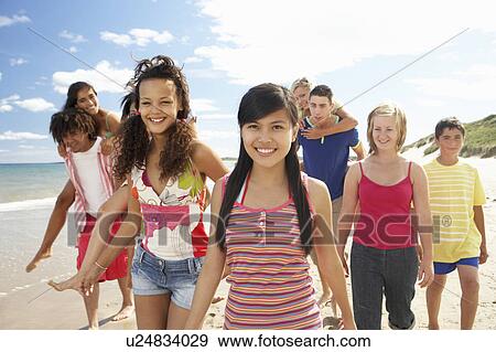 Stock Photo - Teenagers walking on beach. Fotosearch