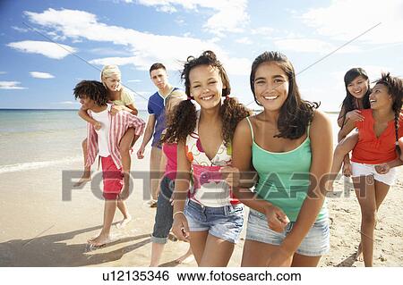 Teenagers walking on beach View Large Photo Image Stock Photograph - Teenagers walking on beach. Fotosearch