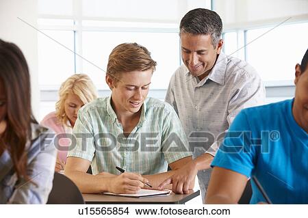 Picture - Tutor helping student in class. Fotosearch