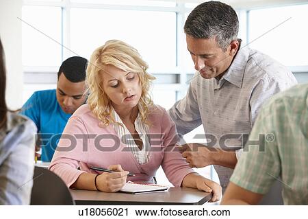 Tutor helping student in class View Large Photo Image Stock Image - Tutor helping student in class. Fotosearch
