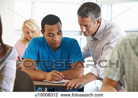 Tutor helping student in class View Large Photo Image Stock Image - Tutor helping student in class. Fotosearch