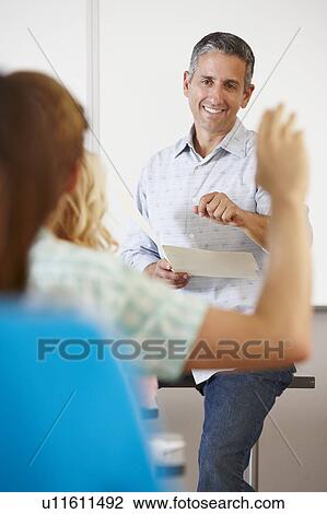 Stock Image - Tutor with class of students. Fotosearch