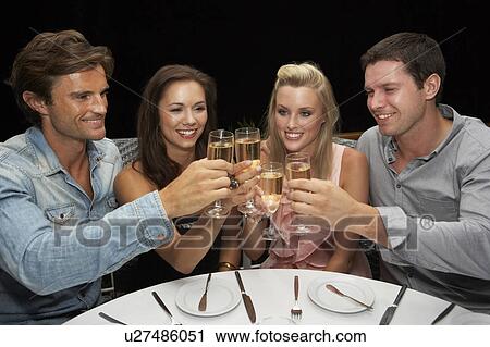 Stock Image - Two young couples in restaurant. Fotosearch