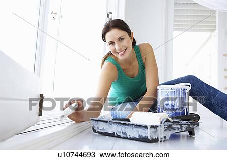 Stock Image - Woman decorating house. Fotosearch