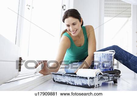 Stock Image - Woman decorating house. Fotosearch