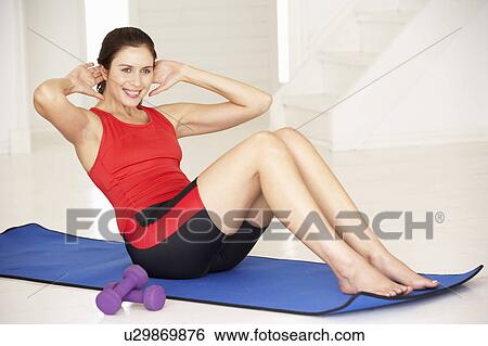 Woman doing sit-ups in home gym View Large Photo Image Stock Photograph - Woman doing sit-ups in home gym. Fotosearch