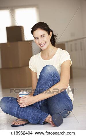 Picture - Woman moving into new home. Fotosearch