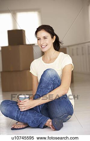 Stock Photography - Woman moving into new home. Fotosearch