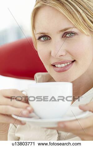 Stock Image - Woman relaxing with cup of tea. Fotosearch