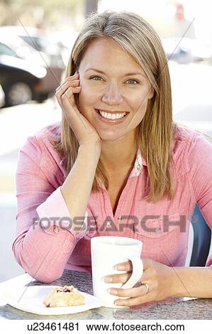 Woman sitting at sidewalk café View Large Photo Image Stock Image - Woman sitting at sidewalk café. Fotosearch