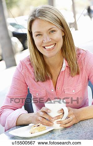 Stock Photo - Woman sitting at sidewalk cafÃ©. Fotosearch