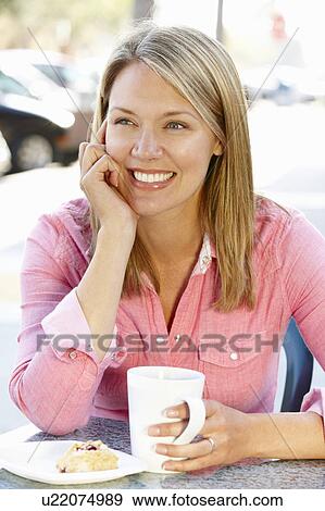 Woman sitting at sidewalk café View Large Photo Image Stock Photo - Woman sitting at sidewalk café. Fotosearch