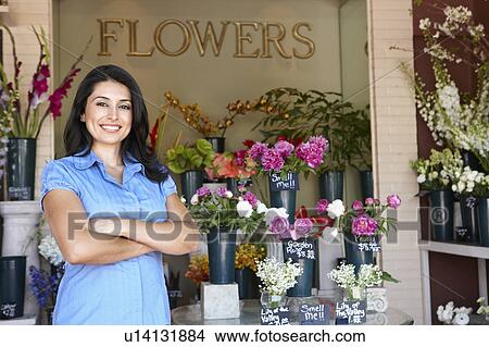 Picture - Woman standing outside florist. Fotosearch