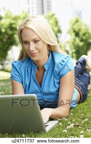 Stock Photo - Woman using laptop in city park. Fotosearch
