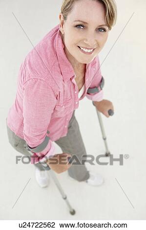 Woman walking with crutches View Large Photo Image Stock Image - Woman walking with crutches. Fotosearch