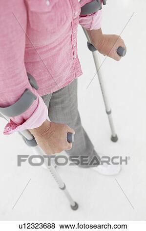 Woman walking with crutches View Large Photo Image Stock Photo - Woman walking with crutches. Fotosearch