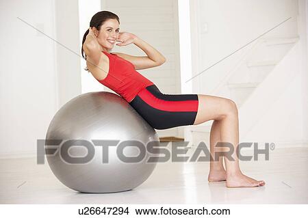 Woman with gym ball in home gym View Large Photo Image Picture - Woman with gym ball in home gym. Fotosearch