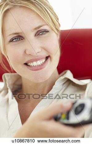 Stock Image - Woman with remote control. Fotosearch