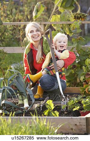 Woman working on allotment with child View Large Photo Image Stock Photography - Woman working on allotment with child. Fotosearch