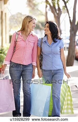 Stock Photo - Women carrying shopping. Fotosearch