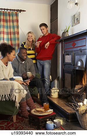 Young adults making toast on open fire View Large Photo Image Stock Image - Young adults making toast on open fire. Fotosearch