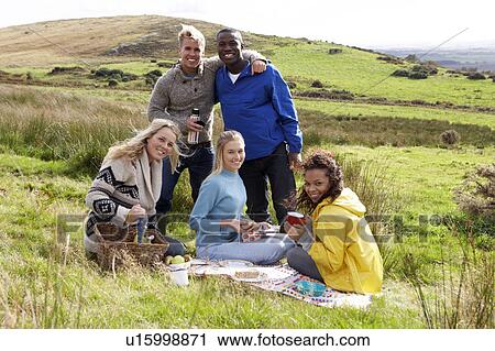 Stock Image - Young adults on country picnic. Fotosearch