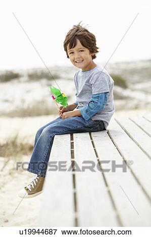 Stock Photo - Young boy on beach with windmill. Fotosearch