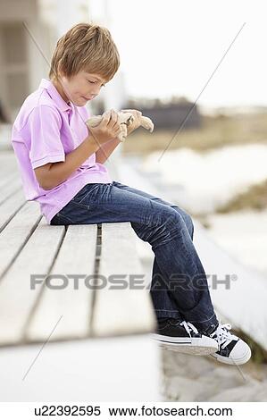 Young boy outdoors holding starfish View Large Photo Image Stock Photography - Young boy outdoors holding starfish. Fotosearch