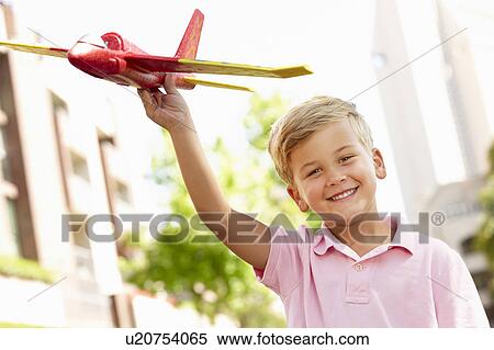 Young boy outside with toy aeroplane View Large Photo Image Stock Photography - Young boy outside with toy aeroplane. Fotosearch