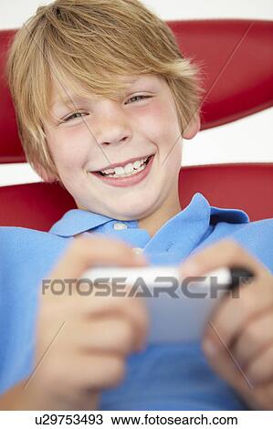 Young boy using cellphone View Large Photo Image Stock Image - Young boy using cellphone. Fotosearch