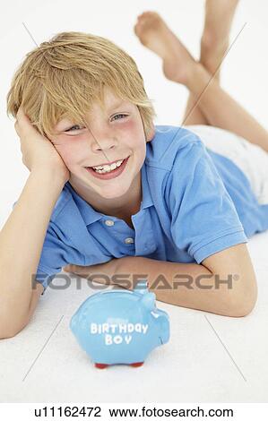 Stock Image - Young boy with piggy bank. Fotosearch