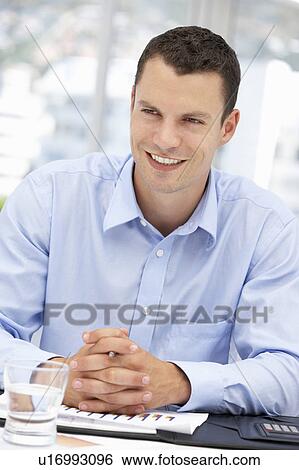 Young businessman at desk View Large Photo Image Stock Photograph - Young businessman at desk. Fotosearch