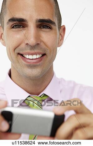 Picture - Young businessman using cellphone. Fotosearch