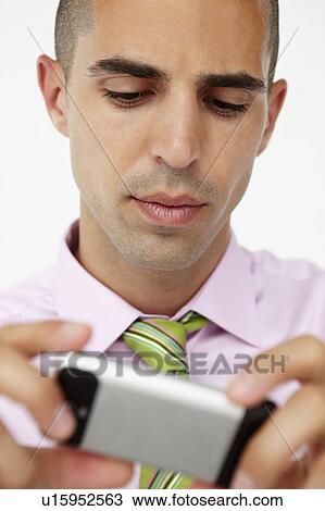 Stock Image - Young businessman using cellphone. Fotosearch