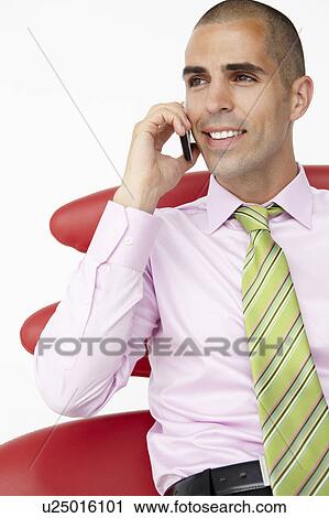 Stock Image - Young businessman using cellphone. Fotosearch