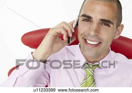 Young businessman using cellphone View Large Photo Image Stock Photo - Young businessman using cellphone. Fotosearch