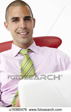 Stock Photograph - Young businessman using laptop. Fotosearch