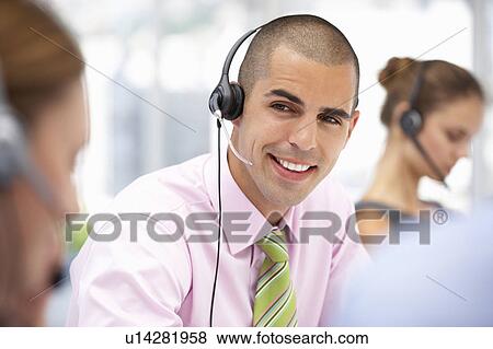 Stock Photo - Young businessman wearing headset. Fotosearch